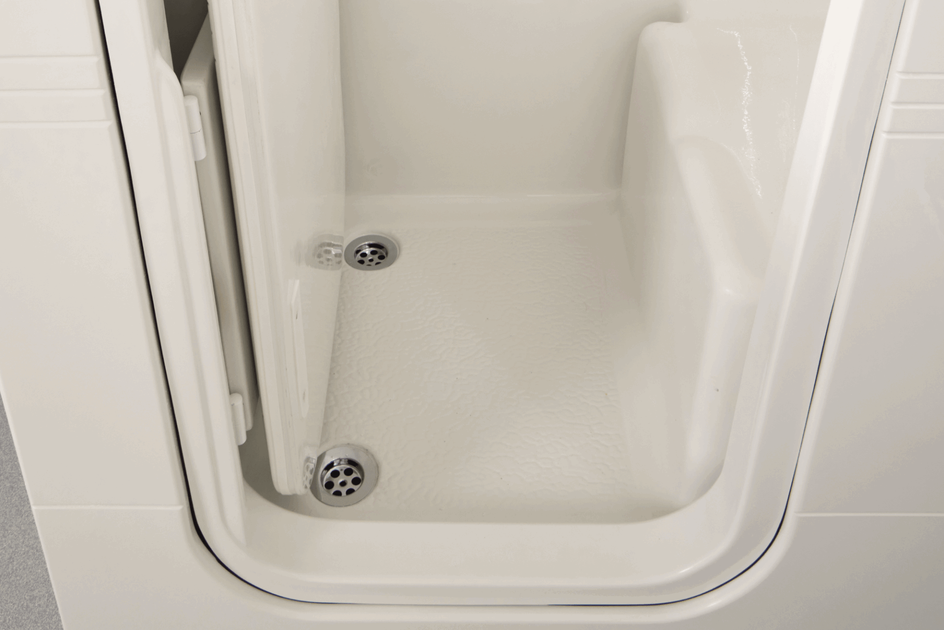 Walk-in bath interior showing anti-slip seat and dual drains